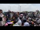 Afghans wait in the open near Kabul airport in hope to flee country