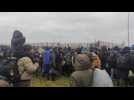Dozens of migrants arrive and wait at the Belarus-Poland border crossing