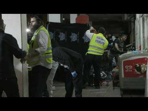 Israelis gather on site of an attack that killed five near Tel Aviv