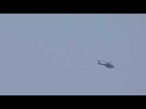 Israeli helicopter lets off flares as smoke rises over Gaza