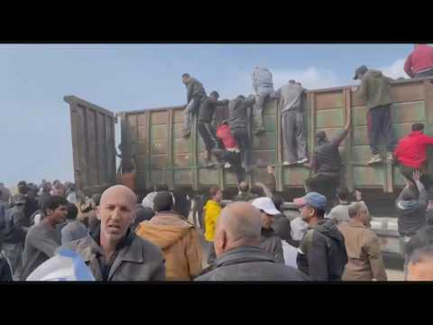 Gazans rush towards aid trucks carrying flour and canned food in Gaza City