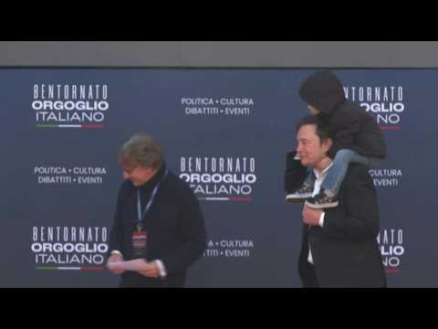 Elon Musk arriving at PM Meloni's party political rally with his young son
