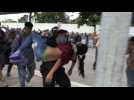Mexican police carries migrants who fainted from border bridge