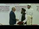 US negotiator and Taliban co-founder shake hands after signing historic deal