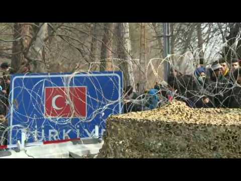 Migrants gather behind barbed wires at the border between Turkey and Greece