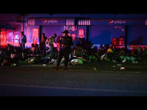 Honduran migrants rest on street under watchful eye of Guatemala police
