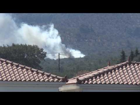 Fire fighting helicopter douses Lesbos migrant camp