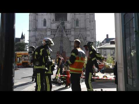 Fire fighters outside Nantes cathedral after blaze was brought under control