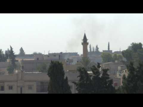 Smoke billows over Syrian border town of Tell Abyad as strikes sound