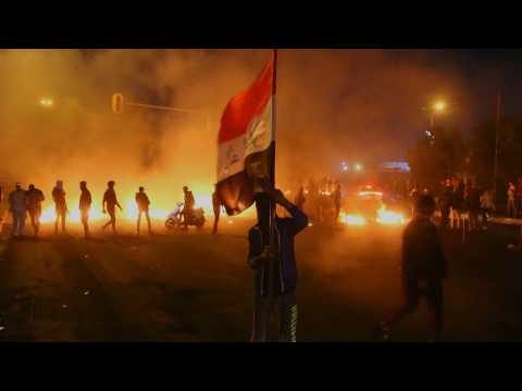 Iraqi anti-government protesters burn tyres and chant slogans in Basra