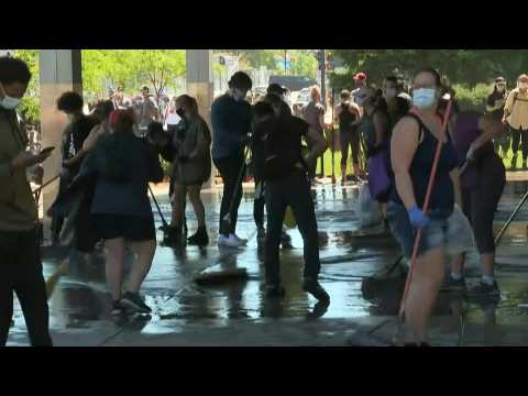 People clean up bank and businesses in Minneapolis after night of protests