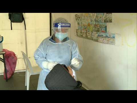 Locals undergo COVID-19 tests at a Bogota bus station