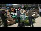 Hundreds line up to receive food handouts in area hard-hit by pandemic