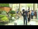 People queue to enter Siam Paragon mall as shopping centres reopen in Thailand