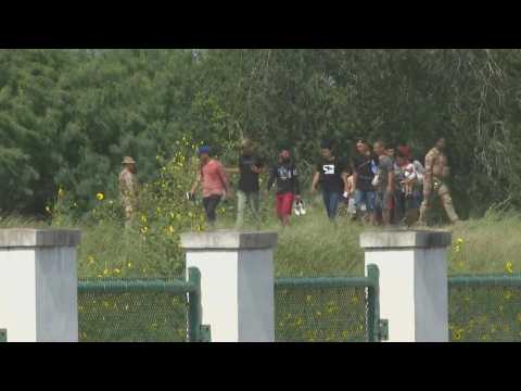 Migrants cross US-Mexico border and surrender to US Customs and Border Protection