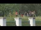 Migrants cross US-Mexico border and surrender to US Customs and Border Protection