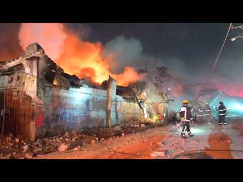 Firefighters tackle a blaze after an explosion in a Dominican shop