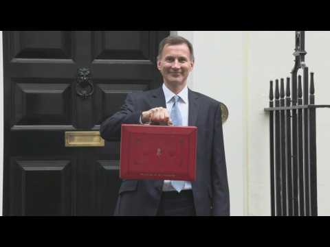 UK finance minister poses with traditional red box ahead of budget announcement