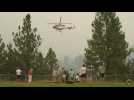 Firefighting helicopters fly through smoky skies over West Kelowna