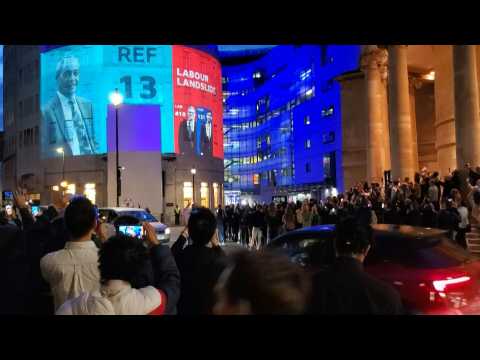 People cheer as exit polls projected onto BBC HQ show Labour landslide in UK election
